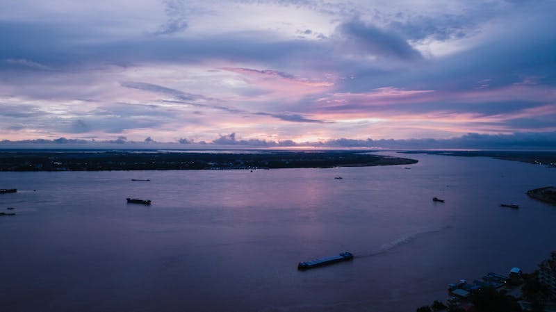 Sunset over Mekong River with boats Phnom Penh